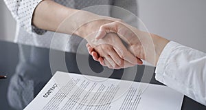 Business people signing contract papers while sitting at the glass table in office, closeup. Partners or lawyers working