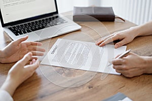 Business people signing contract papers while sitting at the wooden table in office, closeup. Partners or lawyers