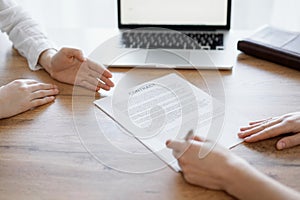 Business people signing contract papers while sitting at the wooden table in office, closeup. Partners or lawyers