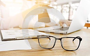 Business people sitting and discussing at business meeting, in office, selected focus on eyeglasses