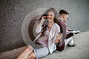 Business people sitting down in front of a modern office building