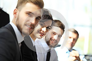 Business people sitting in a row and working, focus on young woman.