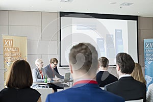 Business people sitting in seminar hall at convention center