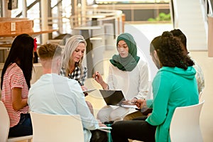 Business people sitting together and having a group discussion in a modern office