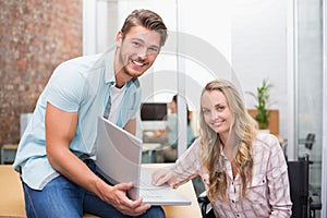 Business people smiling and working together with a laptop