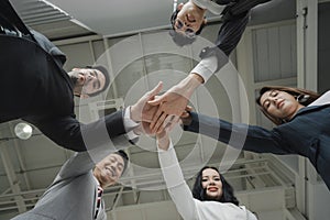 business people stacking hands together in teamwork