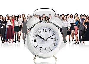 Business people stand near big alarm clock