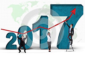 Business people standing with numbers 2017 and graph