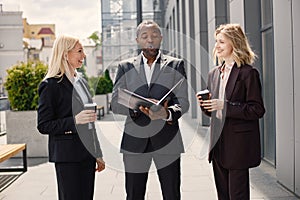 Business people standing and talk to each other in front of modern office