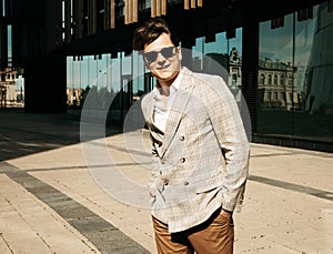 Business, people and success concept: Handsome young business man in fashinable outfit and sunglasses