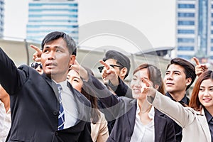 Business people success team pointing to the target blurred city street background, Success and Happiness Teamwork concepts