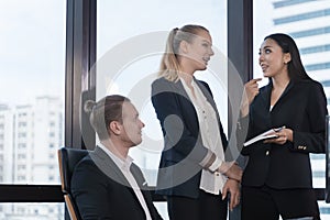 Business people on suit are meeting in office city building view. Group of freinds talking.