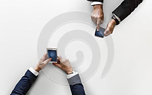 Business people syncing data with mobile phone