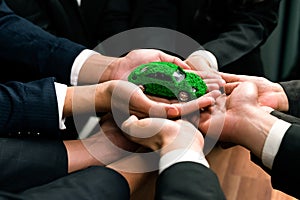 Business people synergy holding EV car model. Quaint