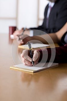 Business people taking notes in a meeting