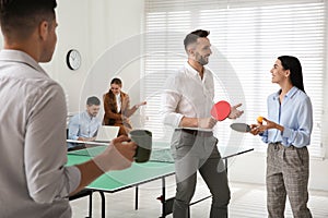 Business people talking near ping pong table in office