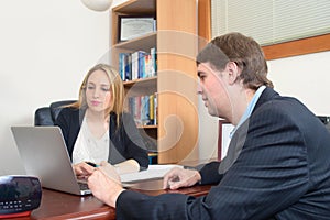 Business people talking over laptop at the table