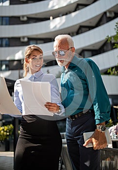 Business people talking about project in front of office building