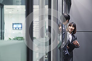 Business people talking together by a glass wall