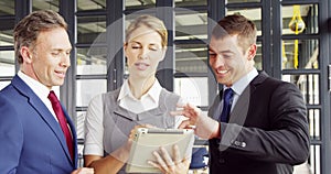Business people talking together while looking tablet