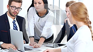 Business people team at meeting in office. Focus at business woman pointing into laptop. Teamwork or coaching concepts