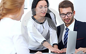 Business people team at meeting in office. Focus at business woman pointing into laptop. Teamwork or coaching concepts