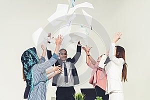Business people throwing papers in the office.