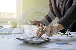 Business people use a calculator to verify their financial information.