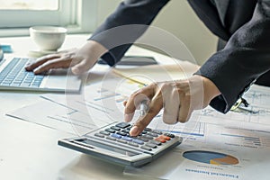 Business people use a calculator to verify their financial information.