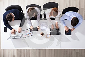 Business People Using Electronic Devices At Desk