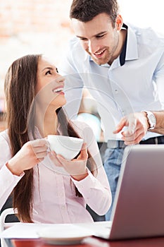 Business people using laptop at cafe