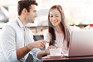 Business people using laptop at cafe