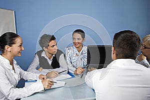 Business people using laptop at meeting