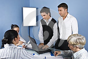 Business people using laptop in office