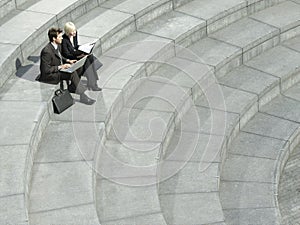 Business People Using Laptop On Spiral Stairs