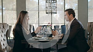 Business people using mobile phone at restaurant. Business couple working phones