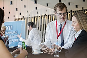 Business people using smart phone during coffee break at convention center