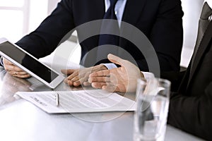 Business people using tablet computer while working together in modern office. Unknown businessman with colleague at