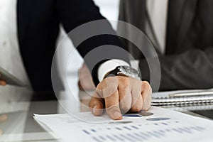 Business people using tablet computer while working together in modern office. Unknown businessman sitting at the desk