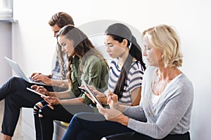 Business people using technologies while sitting on seat