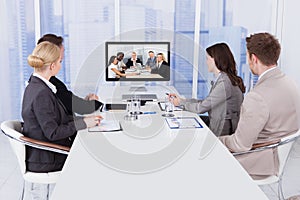 Business people in video conference at table