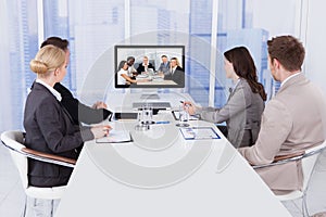 Business people in video conference at table photo