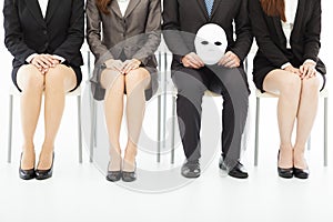 Business people waiting for job interview with a strange mask