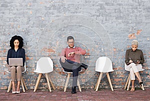 Business people, waiting room and sitting on chairs against brick wall for interview, meeting or opportunity. Group of