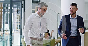Business people, walking and discussion in office lobby with coffee, conversation or networking. Talking, planning or