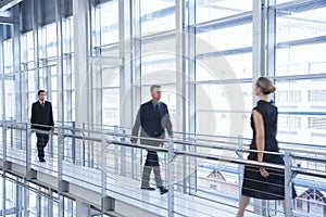 Business People Walking By Railing In Modern Office