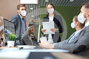 Business people wear preventive masks during epidemy in office.