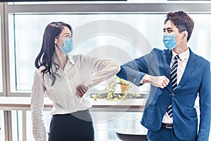 Business people wearing medical mask and   striking with their elbows instead of  handshake