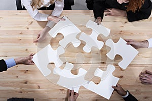 Business people work together to build a puzzle. Concept of teamwork, partnership, integration and startup photo