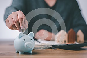 Business people working at desk with piggy bank box.business finance saving and investment concept. hand put money coin into piggy